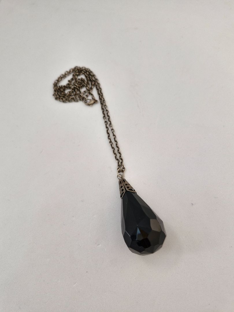 Long necklace with a large black stone