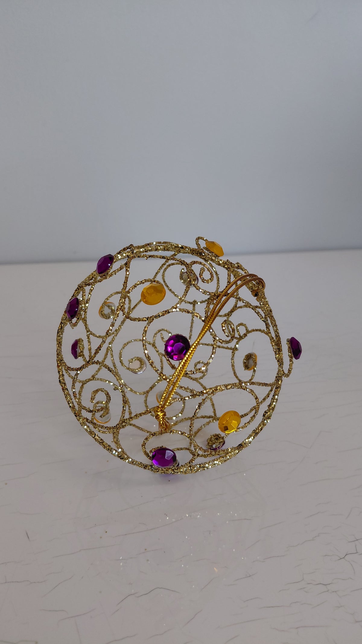 Gyllt jólakúla með steinum í ýmsum litum